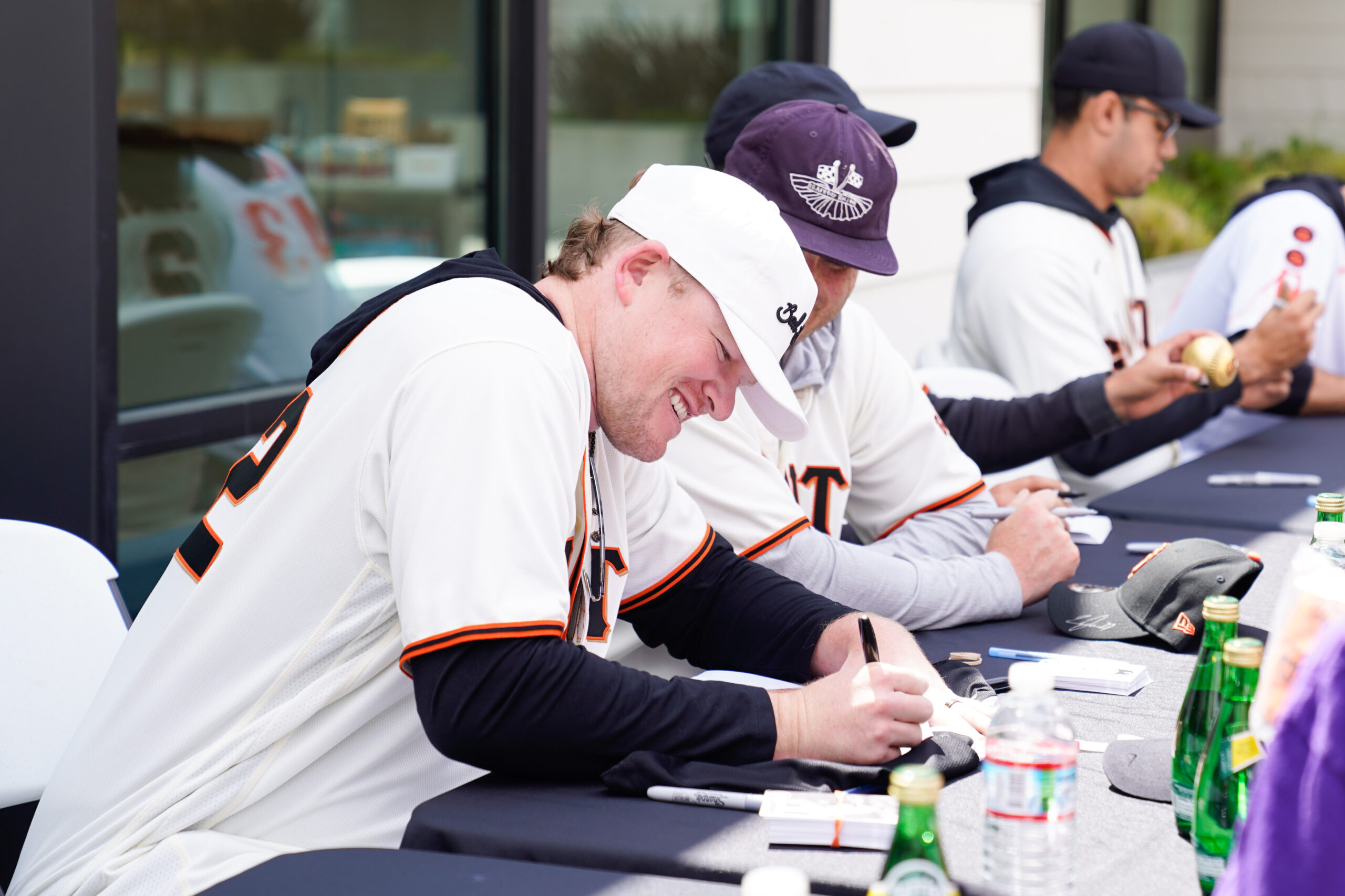 man signing hat