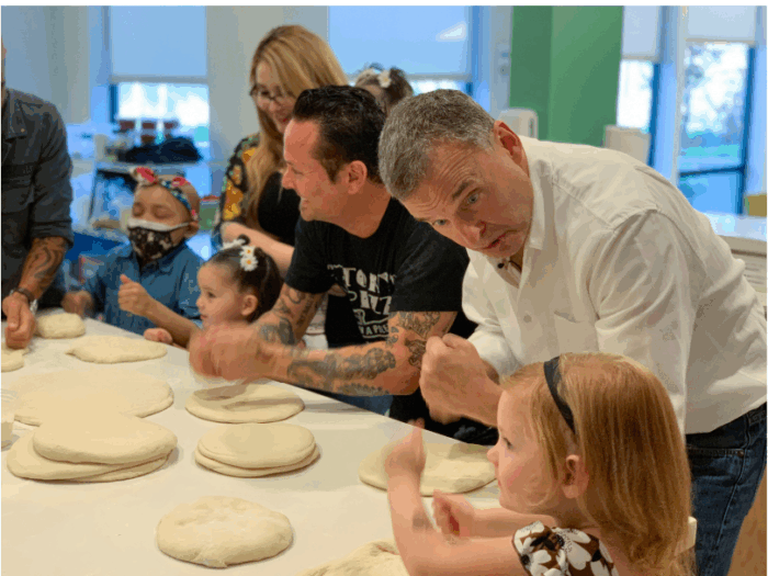 Phil Rosenthal at Family House SF working on pizza dough forming with kids and chefs