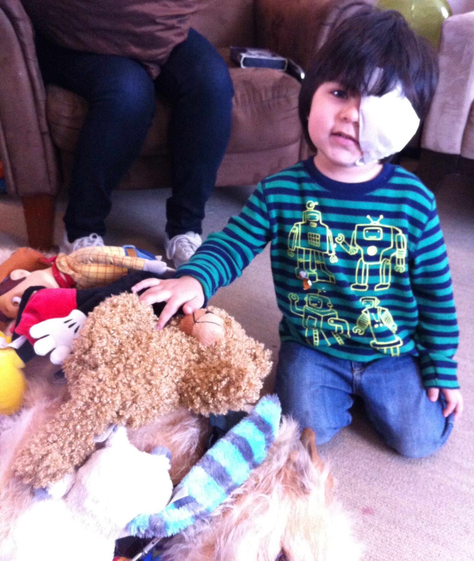 Santiago with therapy dog Fozzy who is covered in stuffed animals