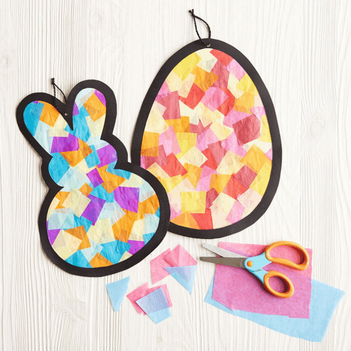 picture of a craft project with an outline of a bunny and an egg filled with squares to look like stained glass; scissors and colored tissue paper are to the side of the image 